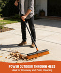 Solid 24 Inch Heavy Duty Push Broom Built Different To Handle The Daily Grind Sweeps Garages Decks Patios Yards Workshops And Concrete Floors Fast With Zero Hassle, cleaning leaves on a patio.