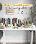 Electric Standing Desk With Four Memory Presets And No Sweat Height Adjustment In White, with books and accessories organized on top.
