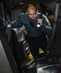 Officer using UltraStinger 77555 1100 Lumen Tactical Duty Flashlight With 65000 Candela Long Range Beam in vehicle inspection.
