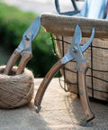 Workhorse Wood Handle Pruning Shears With SK-5 Blade beside twine, showcasing 8 inch length, 1 inch cutting capacity, in garden setting