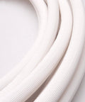 Close-up of white insulated copper coil line tubing for HVAC refrigerant, 1/4" copper with 1/2" insulation