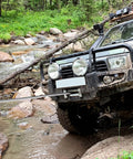 SUV using Beefy Heavy Duty 3/8 Inch By 100 Foot Steel Winch Cable With 15,200 Lbs Breaking Strength to cross rocky stream