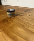 Real Deal Food Grade Beeswax Wood Polish And Cutting Board Wax, Zero Hustle Multi Surface Protectant That Keeps Kitchen Counters And Dining Tables Lookin Fresh, Smooth Finish Coating, Nine Oz Jar on a wooden table.