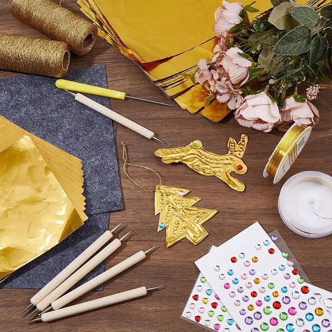 Metal Sheet Embossing Kit For Tin Foil Art And Embellished Designs with tools, gold foil sheets, copper wire, and decorations.