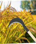 Manganese Steel Long Handle Scythe For Gardening in a field, showcasing one-handed grip and blade for efficient grass removal.