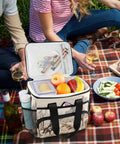 Desert Cowboy Insulated Lunch Bag With Shoulder Strap, Reusable Cooler Tote for picnic, showing fruits and drinks on a plaid blanket.