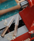 MT2 Cleaner For Wood Lathe Spindles on red lathe, showing handheld wooden cleaning tool for inside MT2 tapers in headstock and tailstock.