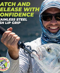 Smiling angler using stainless steel fish lip grip with ergonomic handle to hold fish in saltwater setting