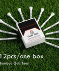 Box and 12 white bamboo golf tees arranged on grass showcasing 12pcs/one box packaging. 24 Piece Premium Bamboo Golf Tees 83mm 3.25 Inches With Vintage Carry Case Funny Golf Accessory For Golfers Awesome Gift For Men And Women Who Love The Game.