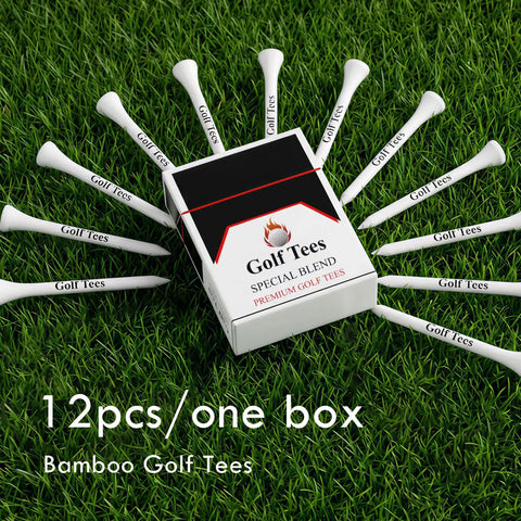 Box and 12 white bamboo golf tees arranged on grass showcasing 12pcs/one box packaging. 24 Piece Premium Bamboo Golf Tees 83mm 3.25 Inches With Vintage Carry Case Funny Golf Accessory For Golfers Awesome Gift For Men And Women Who Love The Game.