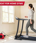 Woman walking on treadmill with Heavy Duty Three Speed Floor Fan With 156W 550 CFM Air Mover For Quick Drying And Cooling nearby