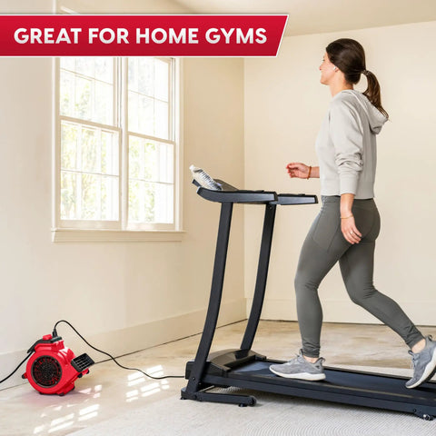 Woman walking on treadmill with Heavy Duty Three Speed Floor Fan With 156W 550 CFM Air Mover For Quick Drying And Cooling nearby