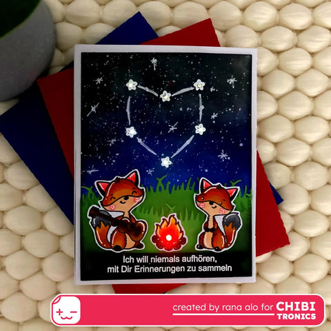 Handmade card featuring foxes, stars, and a heart constellation with text, created using Chibitronics materials for a craft project.