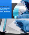 Person peeling protective film from Ultra Clear Full Face Shield Pack of 200 in 20 Packs of 10, Pro Grade Anti Fog PET Plastic.