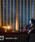 Child sitting by window with Solar Curtain Lights 7.9 Feet By 6 Feet With 144 LEDs Outdoor Waterproof Fairy String Lights glowing