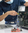 Person repairing computer with DIY Spot Weld Machine Control Board With Time And Current Adjustable Controller visible on desk.