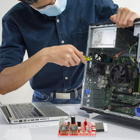 Person repairing computer with DIY Spot Weld Machine Control Board With Time And Current Adjustable Controller visible on desk.