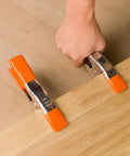 Hand using Heavy Duty Spring Clamp Set 4-Inch And 6-Inch Clamps With 1-Inch And 2-Inch Jaw Openings on wooden board