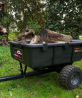 10 Cu Ft Heavy Duty Tow Behind Poly Utility Cart Dump Trailer With Magnetic Hitch Pin loaded with firewood in garden