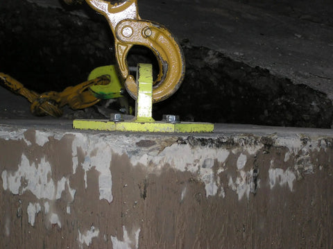 Close-up of a heavy duty concrete screw anchor five eighth inch by four inch hex washer head zinc plated Titen HD pack of 10 installed in cracked concrete