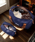 TAKUMI navy 3-piece luggage set with a duffel bag; large carry-on opened to reveal interior, sunglasses, and scarf.
