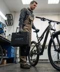 Mechanic holding All In One 33 Piece Bike Tool Kit For Road And Mountain Bikes And E Bike Repairs in workshop with bike