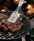 Multifunction 11 Inch Premium Stainless Steel Tongs 3 In 1 Gripper Flip And Scraper lifting steak on grill