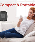 Small Space Heater 1500W Ceramic Indoor Heater With 3 Settings next to relaxed woman holding phone on sofa.