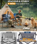 Two people sitting on an Oversized Camping Directors Chair With Side Table by a lakeside campfire with a dog.