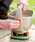 Man using No Crank One Touch Battery Powered Spreader for Fertilizer Seed and Ice Handheld Spreader with EdgeGuard Tech on lawn