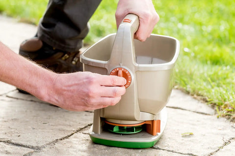 Man using No Crank One Touch Battery Powered Spreader for Fertilizer Seed and Ice Handheld Spreader with EdgeGuard Tech on lawn