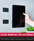 Velcro Brand heavy-duty 4x2 in adhesive mounting strips, black; two strips on wall beside a tablet.