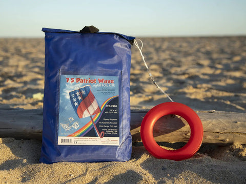 Patriot Wave 7.5 Parafoil Kite package on beach, Easy To Fly Single Line Beginner Kite With No Assembly, 28 W x 36 H x 10 D