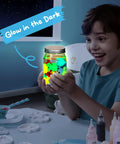 Child excitedly holding Glow In The Dark Water Gel Kit For Kids with Ten Gels Twelve Sea Creature Molds Preserving Bottle and Sparkle Gels.