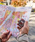 Person holding map and Hiking And Backpacking Compass For Quick Navigation Dope Field Tool With 360 Degree Bezel And Liquid Filled Needle