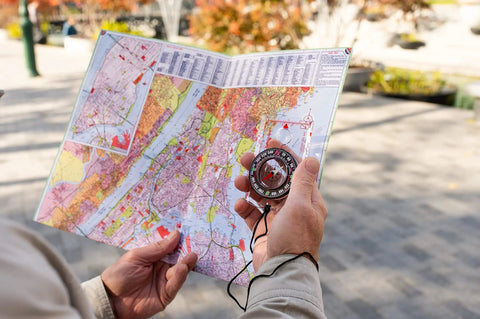 Person holding map and Hiking And Backpacking Compass For Quick Navigation Dope Field Tool With 360 Degree Bezel And Liquid Filled Needle