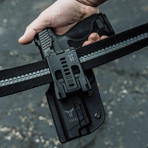 Tough As Nails USA Made Belt Clip Attachment secured on tactical gear with a handgun, ideal for concealed carry use.