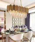 Dining room with elegant gold chandelier and modern decor, highlighting luxurious dining setup with sleek glass table and plush chairs.