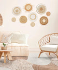 Nine Piece Boho Wall Basket Set Made From Seagrass And Rattan Round Handmade Hanging Baskets For Farmhouse Living Room Bedroom Display Kitchen And Home Decor Eco Friendly Natural Wicker Vibe displayed on beige wall in living room with wicker chair and sofa.