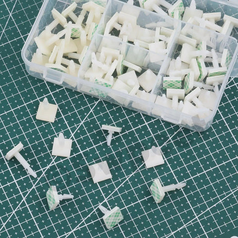 Hella Sturdy White Adhesive Insulated PCB Standoffs Assortment Kit 75 Pack featuring various sizes and shapes scattered on a green mat.