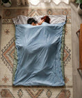 Couple inside Ultralight Backpacking Sleeping Bag For 50 To 70 F Weather, 1.5 Lb Packable To 11.8 X 6.5 Inches, on a rug