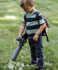 Child using 150BT Inspired Toy Bubble Leaf Blower For Kids, Realistic Air Blast With Lights, Outdoor Toddler Toys in grass field