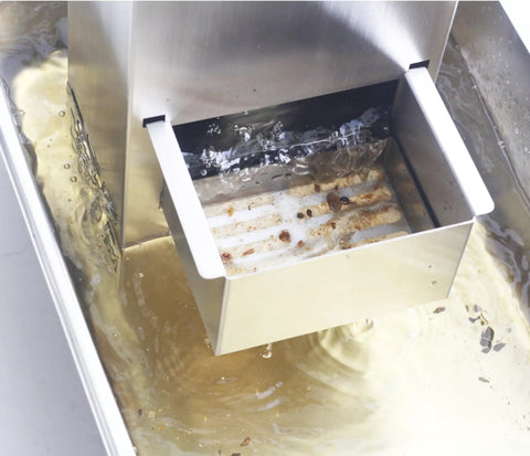 Keep Your Fry Oil Crisp As Day With This Automatic Deep Fryer Oil Filter showing stainless steel gunk filter in cooking oil.