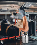 High Performance Pneumatic Paint Sprayer With High Atomization For Cars Furniture Doors And Garden Slick Finish Rapid Painting Tool showcased while a mechanic inspects a car underneath.
