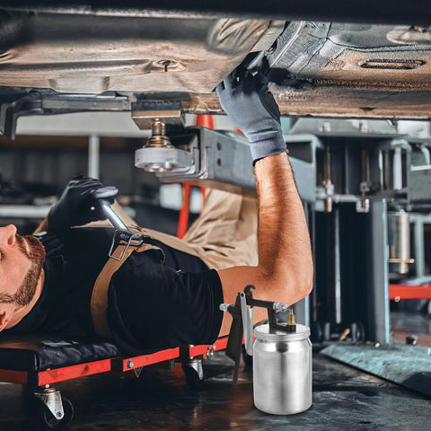 High Performance Pneumatic Paint Sprayer With High Atomization For Cars Furniture Doors And Garden Slick Finish Rapid Painting Tool showcased while a mechanic inspects a car underneath.