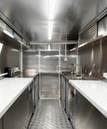 Fully Equipped Mobile Food Trailer With Turnkey Kitchen Setup Featuring Coffee Bar Pizza Oven Hot Dog Station Commercial Freezer Ice Cream Booth interior view showing stainless steel surfaces and sinks.