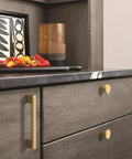 Slick Modern Cabinet Knobs With A Fresh Champagne Bronze Finish on gray kitchen drawers with peppers and decorative items.