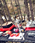 All In One Camping Cooking Utensils Set With 40 Pieces Portable Kitchen Kit displayed outdoors on table with utensils and food