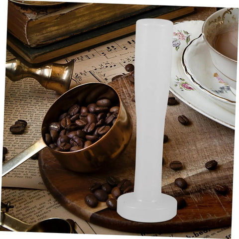 Plastic Espresso Tamper For Home And Commercial Coffee Making No Frills Durable Press Tool on wooden table with coffee beans.