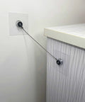 Heavy Duty Stainless Steel No Drill Furniture Straps to Securely Anchor Bookshelves and TVs Against Tipping for Toddler Safety without Damaging Walls Featuring Rock Solid Adhesive Backing Plus Quick Setup installed on a wall and furniture.